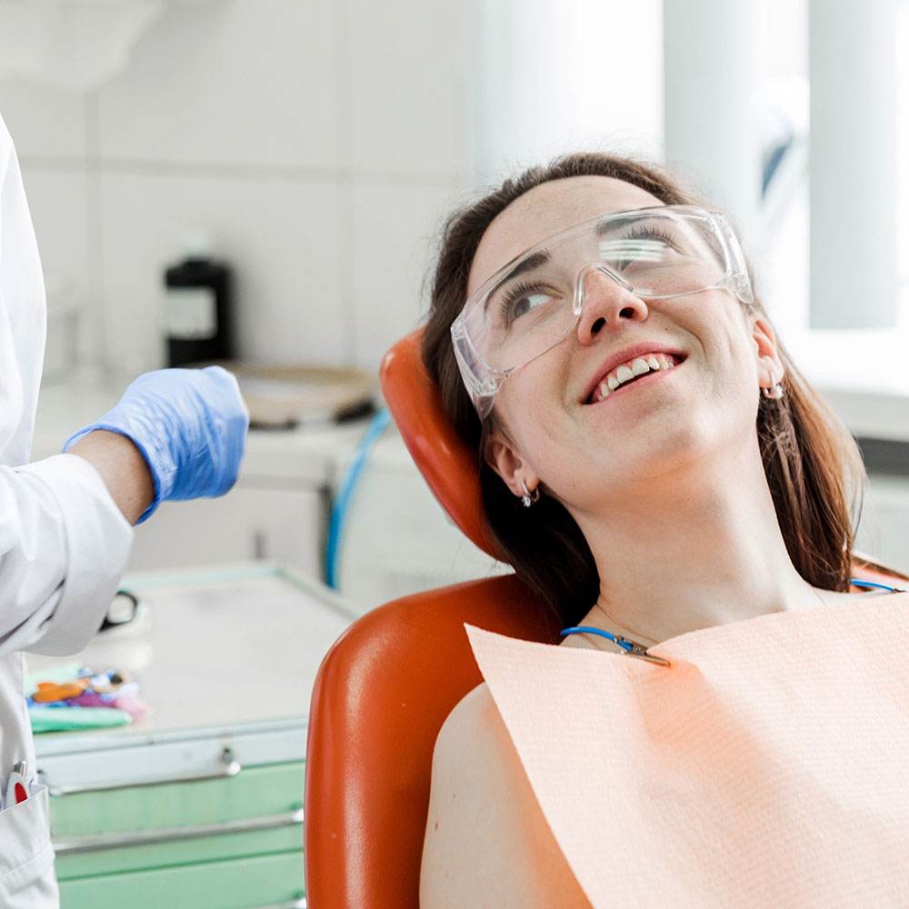 Smiling woman in dental chair looking up at hygenist